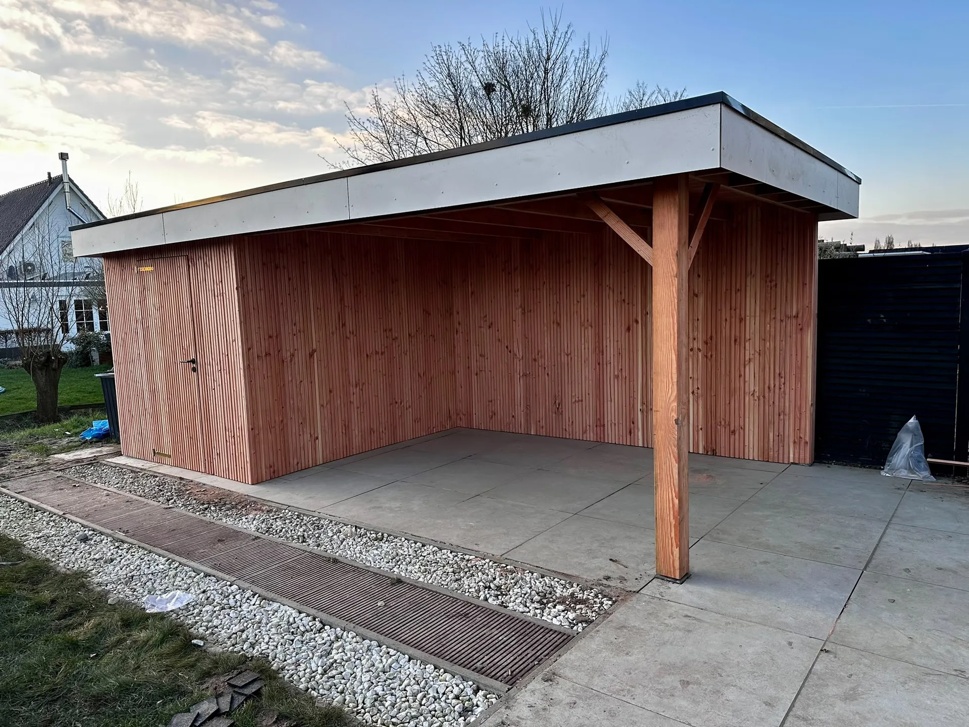Moderne carport met rood golfmetaal en vlak dak