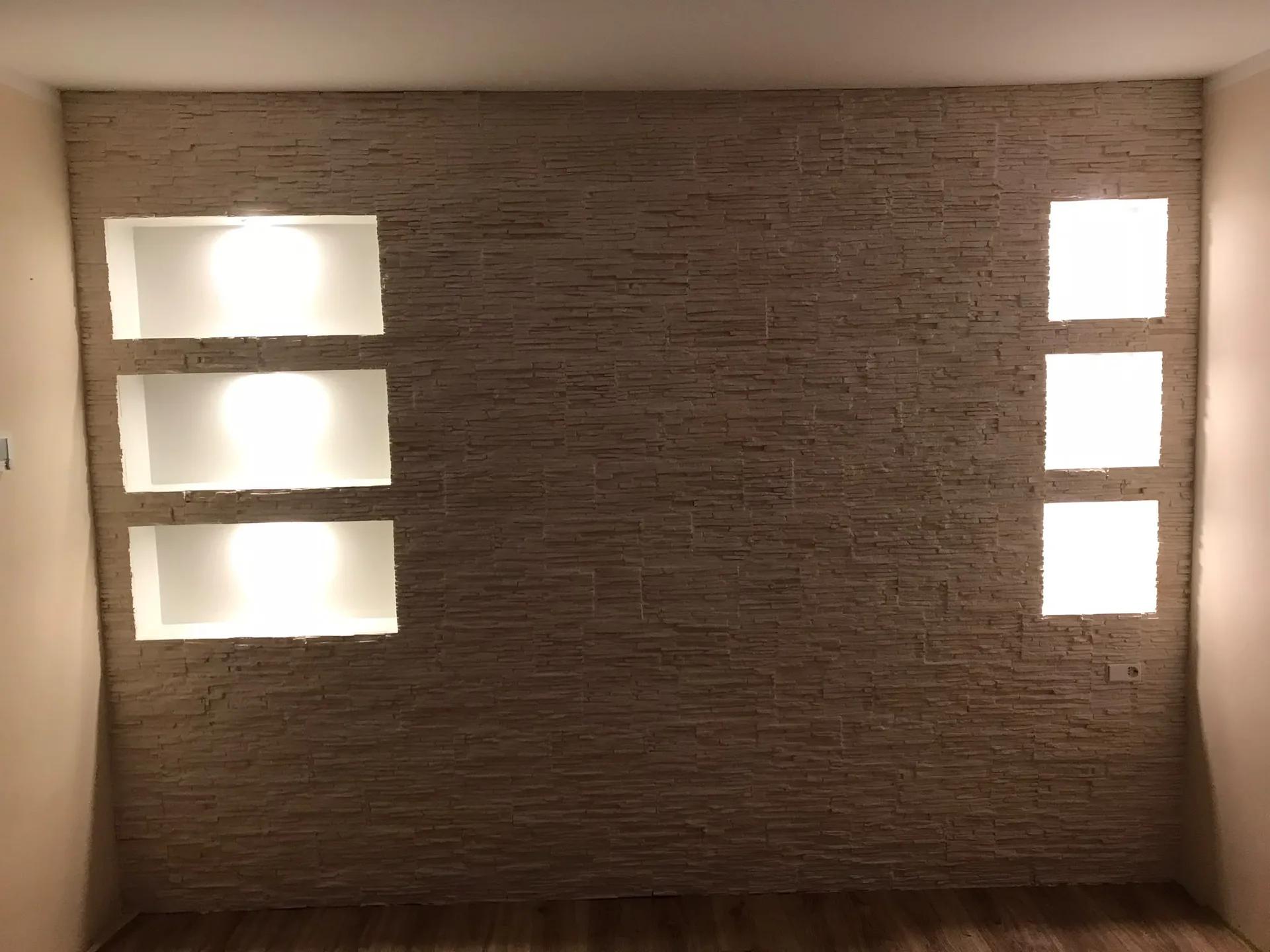 Bakstenen muur met verlichte nissen