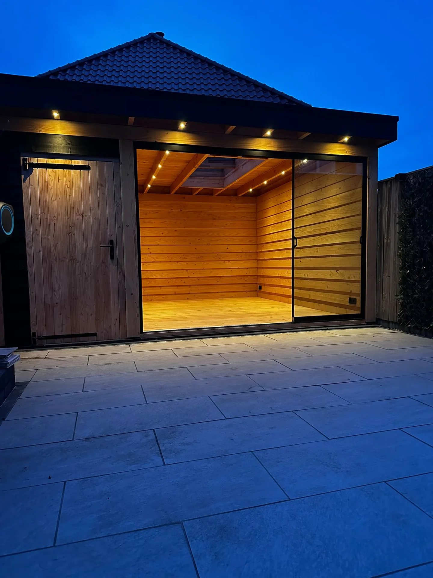 Modern verlicht tuingebouw met glasdeuren