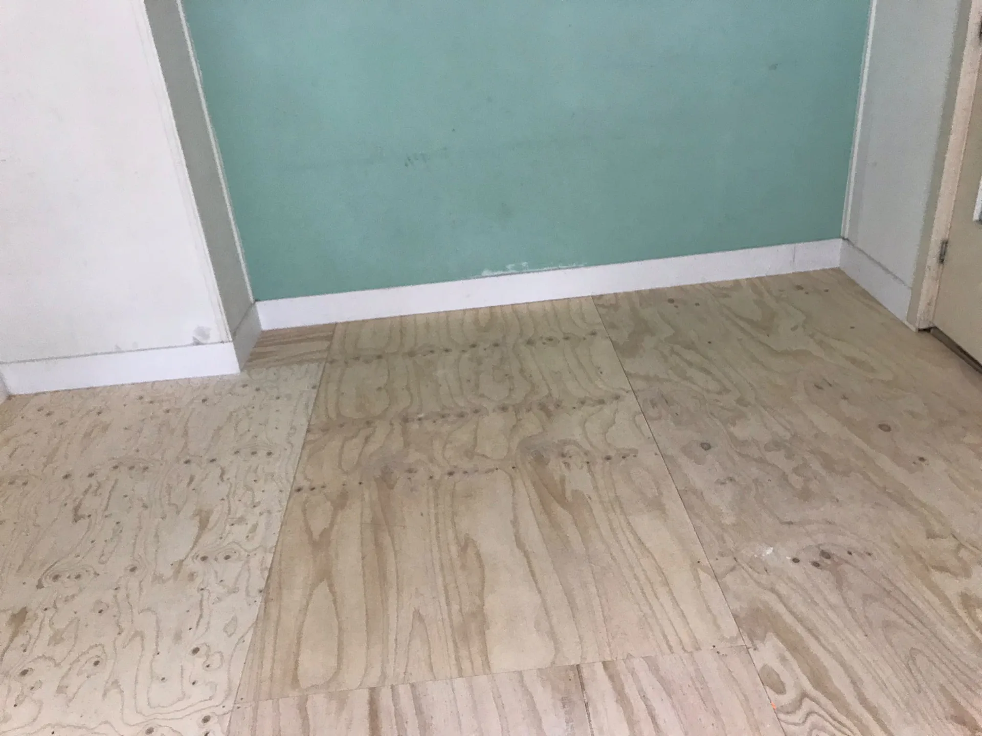 Houten vloer en turquoise muur in renovatie