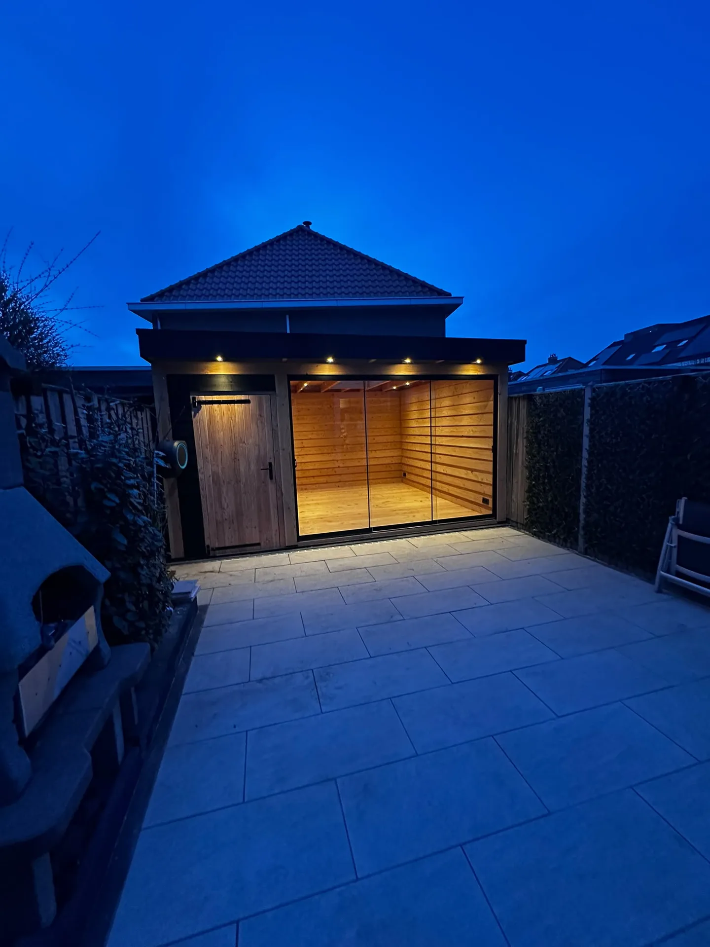 Verlichte moderne tuinkamer bij schemering