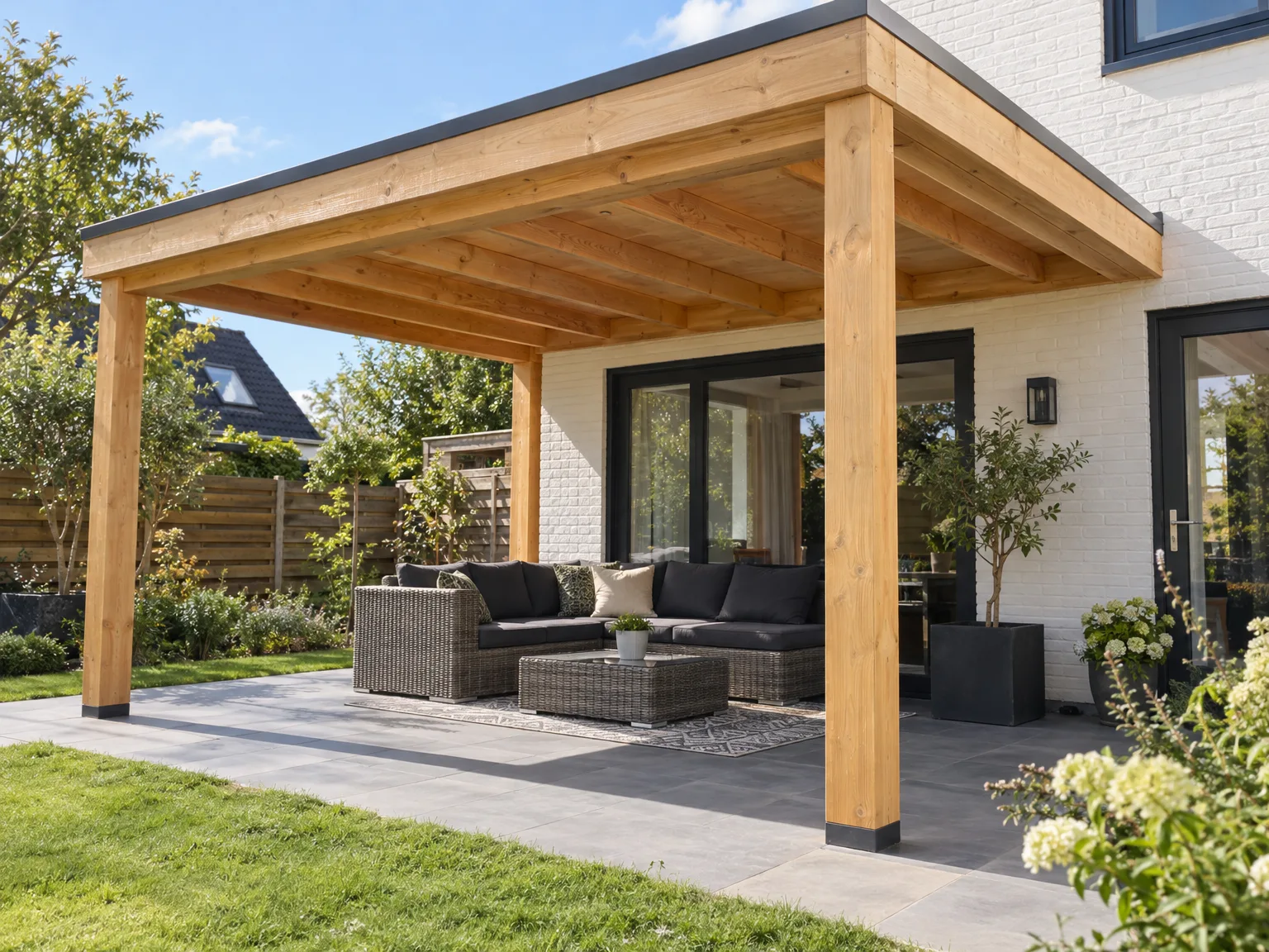 Houten overkapping met duidelijk zichtbare houten balken boven een terras met rieten meubels en zwarte kussens