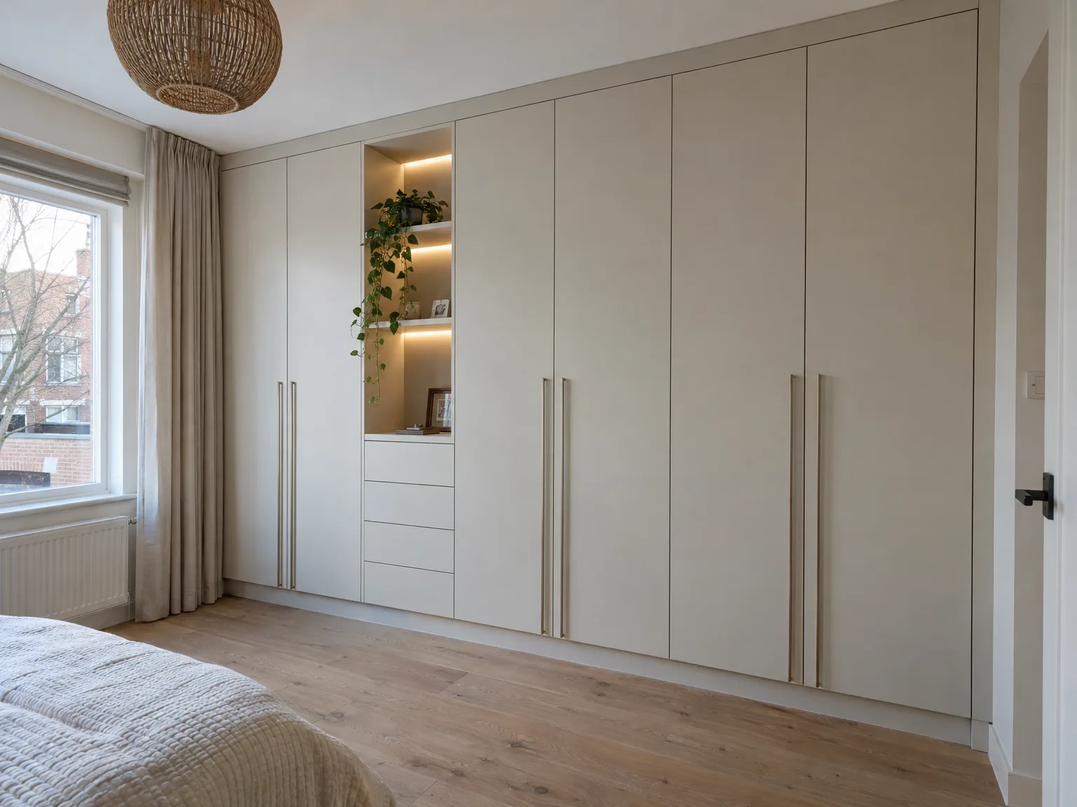 Moderne inbouwkast in slaapkamer met grijze fronten, verlichte open nissen en metalen handgrepen