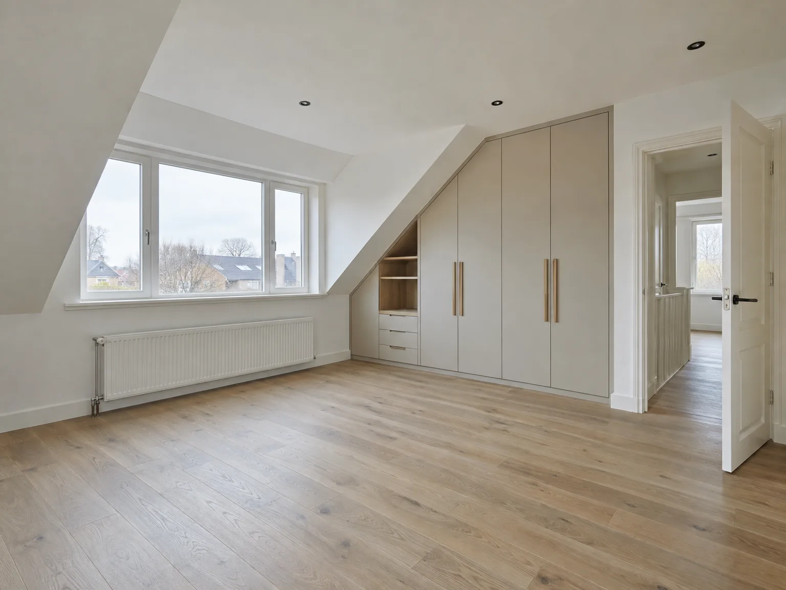 Moderne zolderkamer met houten parketvloer, groot inbouwkastensysteem in beige, gipsplaten en daklicht