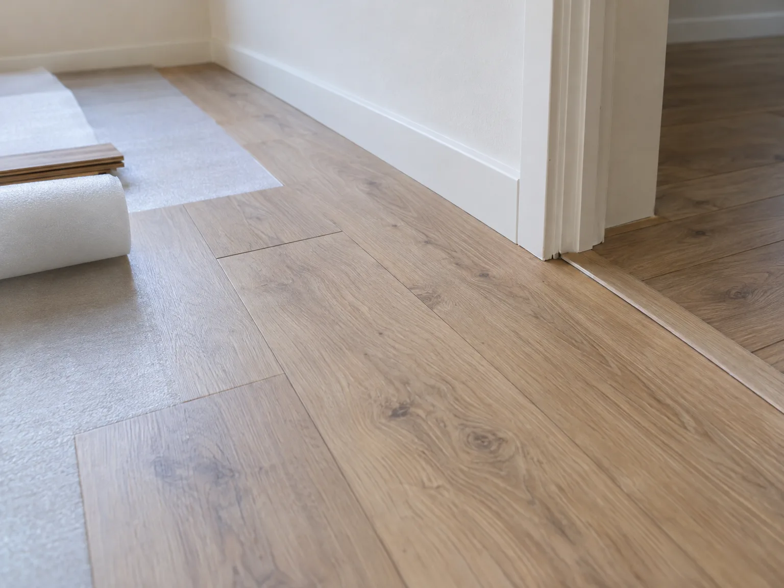 Houten vloer leggen met beschermingsfolie in wit interieur