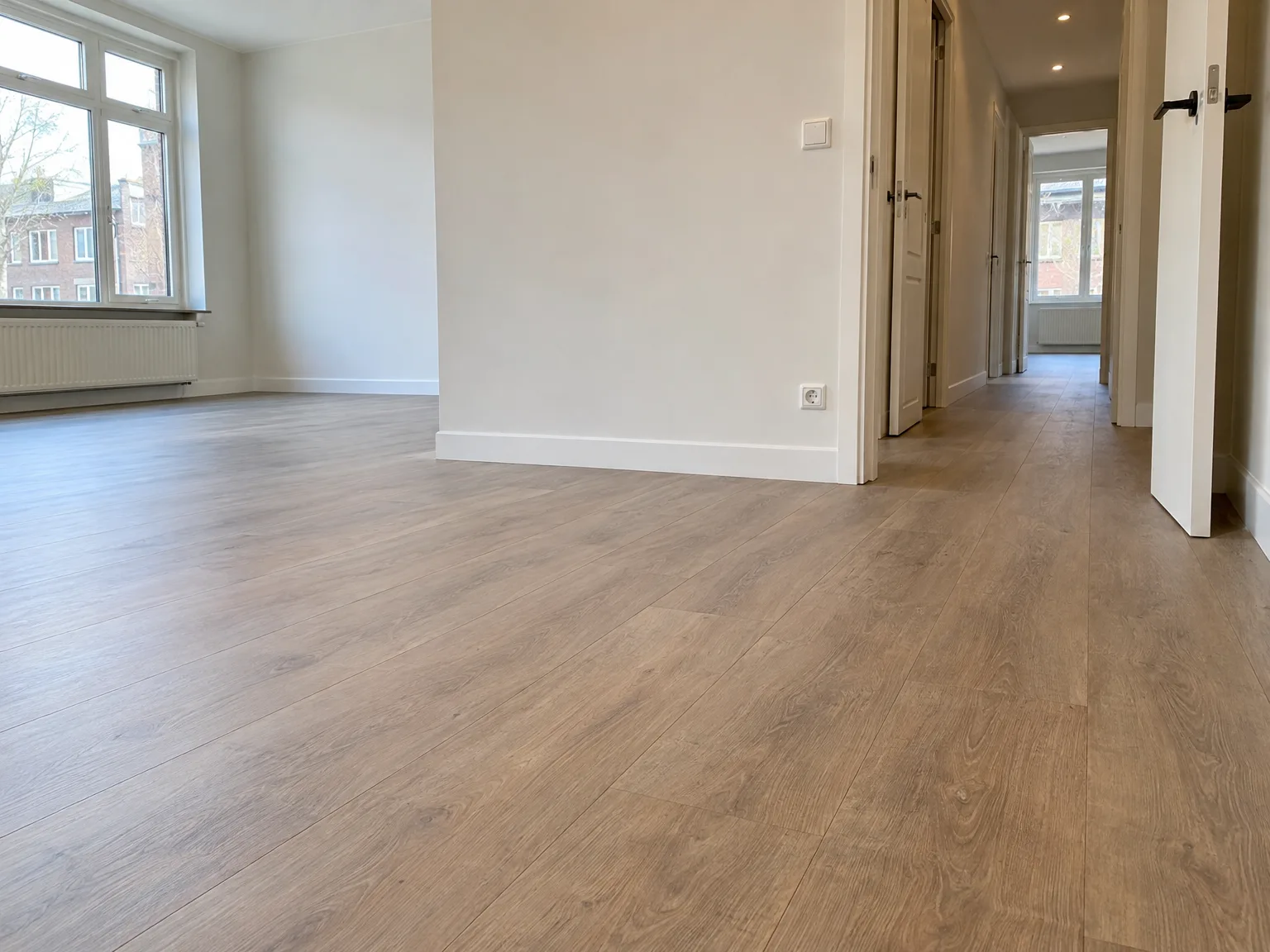 Renovatie afbouw: gipsplaten muren in wit, houten laminaatvloer en moderne afwerking