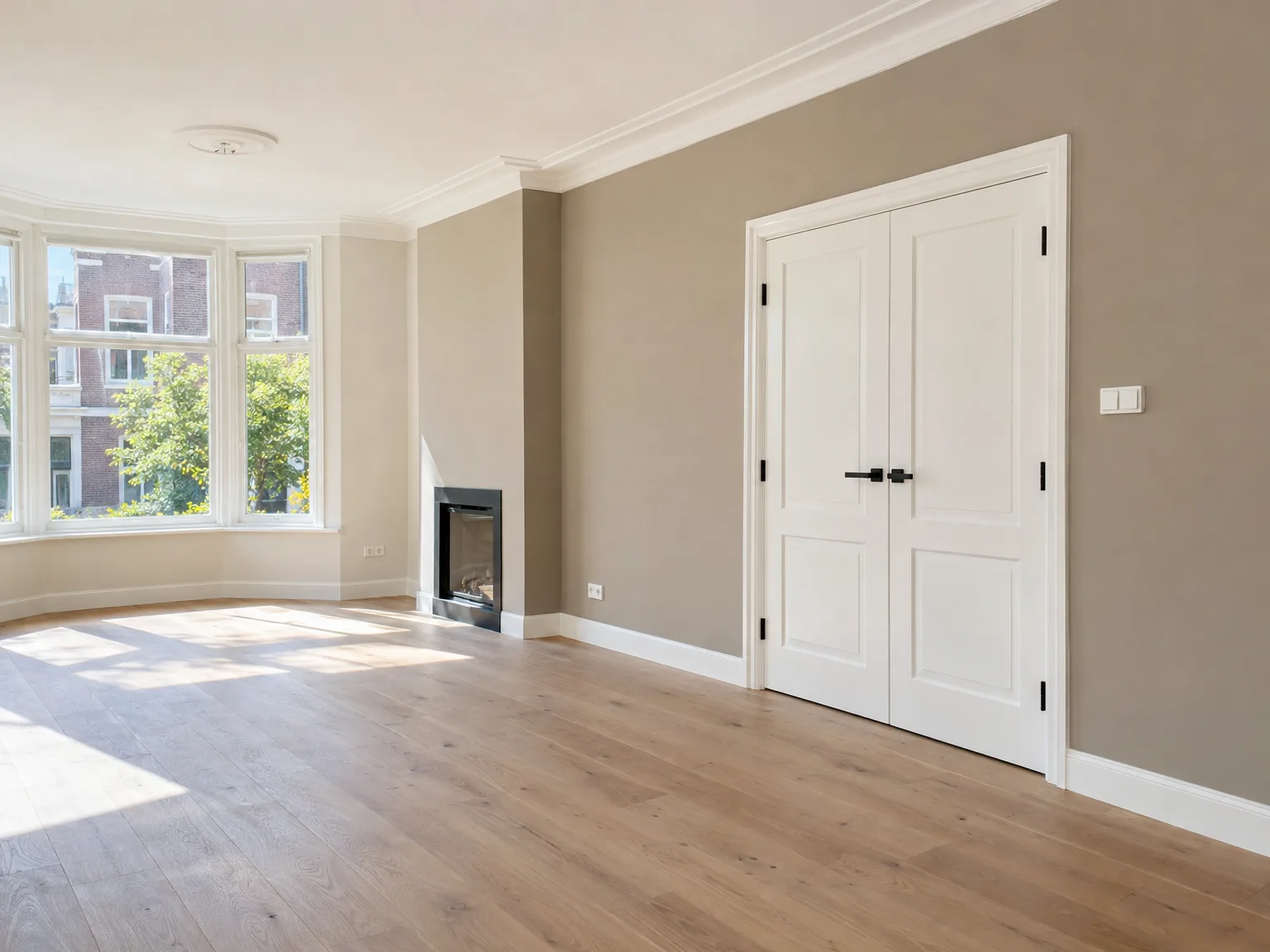 Gerenoveerde woonkamer met houten vloer en professioneel afgewerkte witte deuren