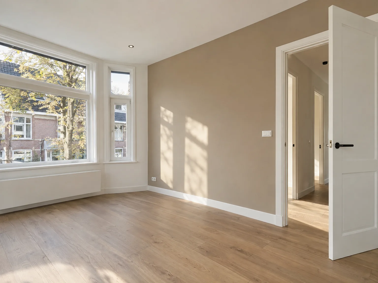 Afgewerkte woonkamer met houten vloer, beige muren en witte deuren