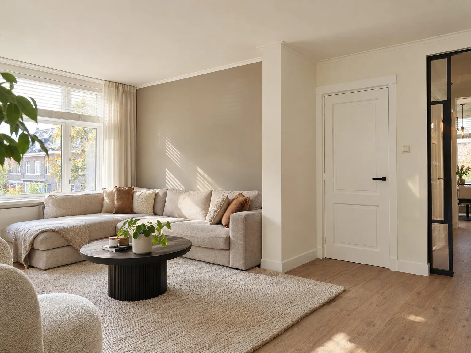Afgewerkte woonkamer met houten vloer, witgelakte deuren en helder interieur