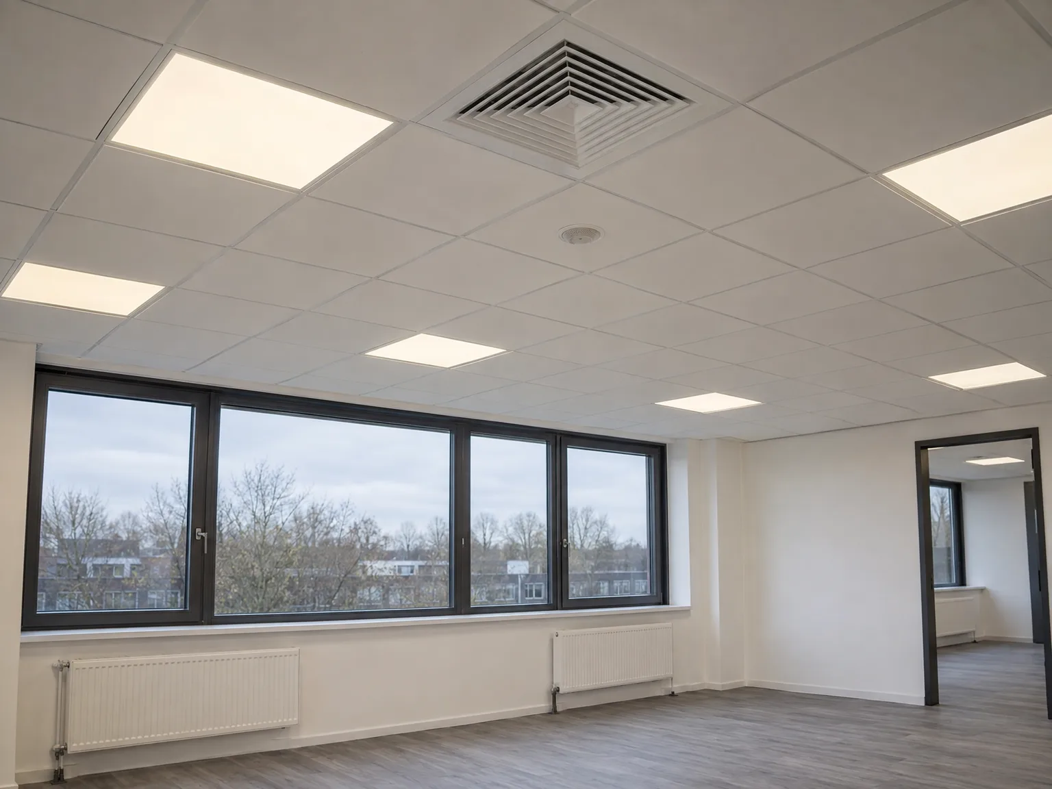Kantoor met systeemplafond, LED-verlichting en moderne ramen na renovatie