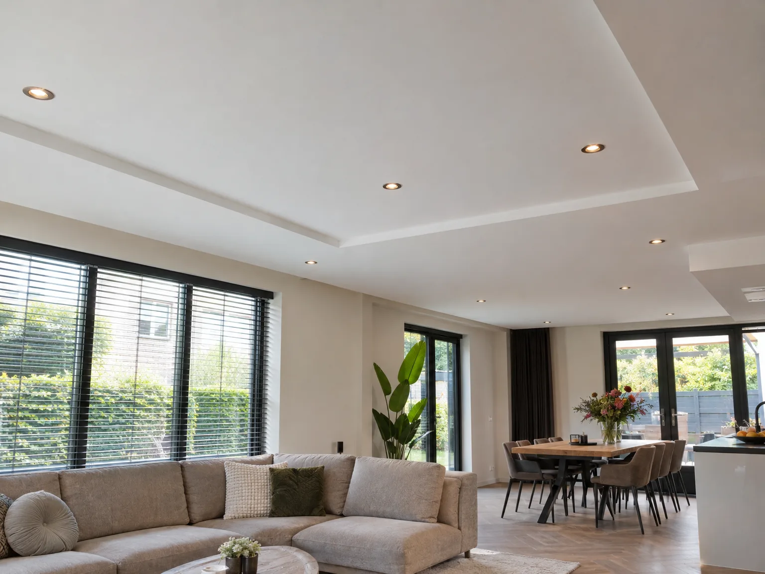 Wit verlaagd plafond met inbouwspots in moderne woonkamer
